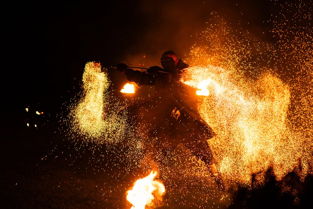 Atlikėjas su žiežirbomis ir liepsnomis abiejose pusėse